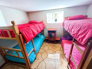 um quarto com 2 beliches e uma mesa em Hostel Climbing Point em Huaraz