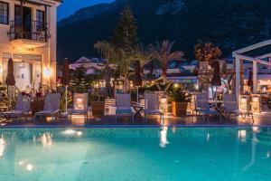 a pool at night with chairs and a hotel at Bronze Hotel in Oludeniz