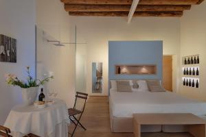 ein Schlafzimmer mit einem weißen Bett und einem Tisch in der Unterkunft Massimago Wine Suites in Verona