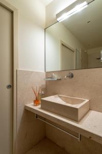 ein Bad mit einem Waschbecken und einem Spiegel in der Unterkunft Massimago Wine Suites in Verona