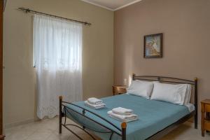 1 dormitorio con 1 cama con toallas en Arba private House en Áyios Dhimítrios