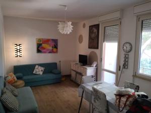 uma sala de estar com um sofá azul e uma mesa em Casa di Vanna em Follonica