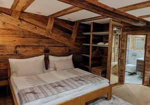 een slaapkamer met een bed in een kamer met houten plafonds bij Boutique Hotel de la Croix-Fédérale in Leukerbad