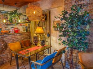 a dining room with a table and chairs and a plant at Pansion Bubamara Mostar in Mostar