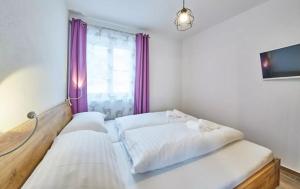 2 camas en una habitación con ventana y cortinas moradas en Goodlife Top 1, en Saalbach Hinterglemm