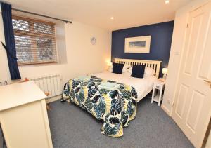 a bedroom with a bed and a table and a window at 2a Mariners Apartments in St Ives