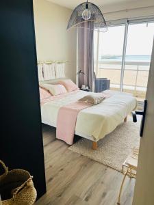 une chambre avec deux lits et une grande fenêtre dans l'établissement Sur le sable 2 3 pers WIFI, à Boulogne-sur-Mer
