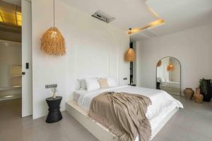 una camera bianca con un grande letto e uno specchio di Designer spacious 2bed Villa, Canggu Pererenan a Munggu