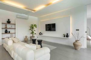 un soggiorno bianco con divano bianco e TV di Designer spacious 2bed Villa, Canggu Pererenan a Munggu