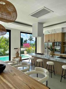una cucina con bar, sedie e tavolo di Designer spacious 2bed Villa, Canggu Pererenan a Munggu