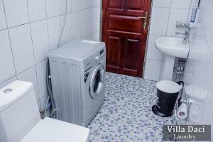 a bathroom with a washing machine and a sink at Villa Daci in Gulu