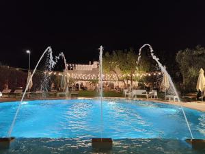 uma piscina com fontes de água em frente a um edifício em Masseria Ancella em Montalbano