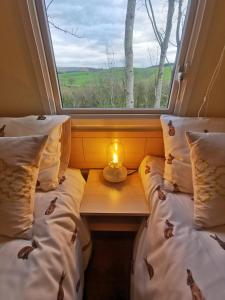a room with two beds and a candle on a table at FAB Caravan Holiday Home in Colmonell