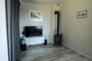 a living room with a flat screen tv sitting on a white cabinet at Dom nad jeziorem w Borzechowie in Borzechowo