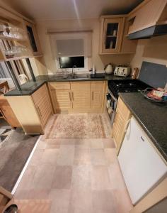 a kitchen with wooden cabinets and a counter top at FAB Caravan Holiday Home in Colmonell