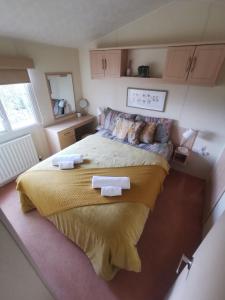 a bedroom with a large bed with two towels on it at FAB Caravan Holiday Home in Colmonell