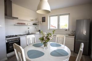 a kitchen with a table with a vase of flowers on it at Dom nad jeziorem w Borzechowie in Borzechowo