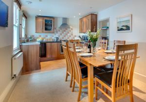 a kitchen and dining room with a wooden table and chairs at Monicas House 8 Porthmeor Square in St Ives