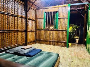 Cama en habitación de bambú con ventana en Saigon Garden Homestay, en Ho Chi Minh