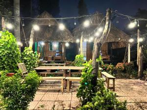 a patio with a bench and a hut with lights at Saigon Garden Homestay in Ho Chi Minh City