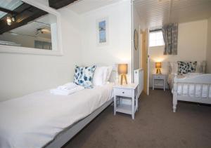 um quarto com uma cama branca e um espelho em 38 Pier View em St Ives
