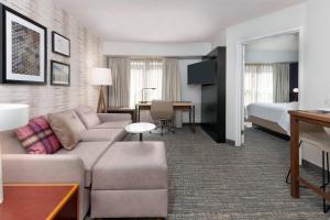 a hotel room with a couch and a bedroom at Residence Inn Mobile in Mobile