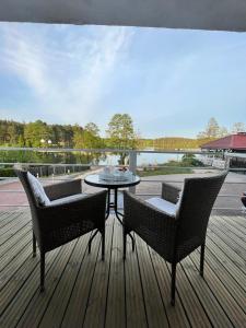 un patio con 2 sillas y una mesa en una terraza en Pokoje Gościnne Villa Plaza, en Ruciane-Nida