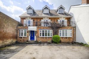 a brick house with a blue door at Victoria Lodge in Kenilworth