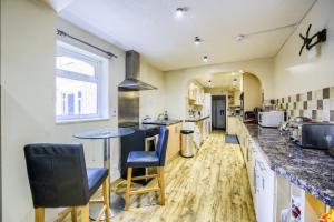 a large kitchen with a table and chairs in it at Victoria Lodge in Kenilworth