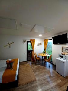 Schlafzimmer mit einem Bett, einem Tisch und einem TV in der Unterkunft The Sun Chalet by Touch the Sky in Moieciu de Jos