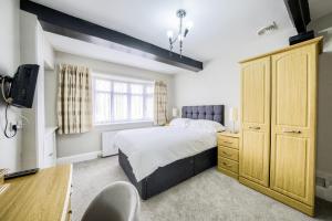 a bedroom with a bed and a dresser and a desk at Victoria Lodge in Kenilworth