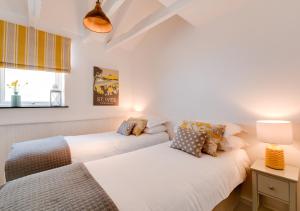 two beds in a room with white walls at Sail Loft Studio in St Ives