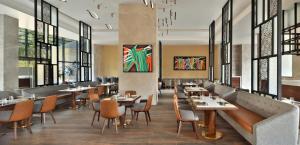 a restaurant with tables and chairs and windows at Courtyard by Marriott Nashik in Nashik