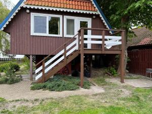 a small house with a staircase leading up to it at Namelis ir marios in Nida