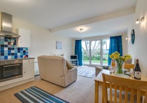 a kitchen and living room with a couch and a table at Seacroft 6 Carthew Court in St Ives