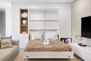 Un dormitorio con una cama grande y un sofá. en Apulia Apartment, en Apúlia