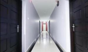 a hallway with two doors and a long corridor at Queens Residency - Kochi in Cochin +13 photos