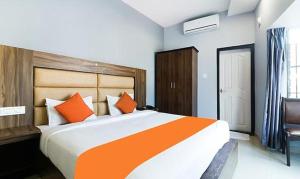 a bedroom with a large bed with orange pillows at Queens Residency - Kochi in Ernakulam