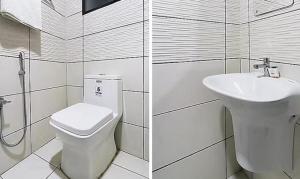 a white bathroom with a toilet and a sink at Queens Residency - Kochi in Cochin