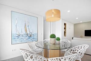 Un comedor con una mesa de cristal y sillas. en Apulia Apartment, en Apúlia