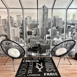 a room with two chairs and a view of the city at ATRIUM Boutique Suites Sofia in Sofia
