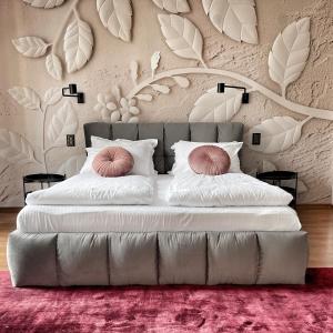 a bedroom with a large bed with white sheets and pink pillows at ATRIUM Boutique Suites Sofia in Sofia