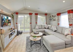 a living room with a couch and a table at Pencnwc Holiday Park in Llanllwchaiarn