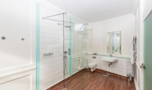 a bathroom with a shower and a toilet and a sink at The Bell Inn Hotel in Horndon on the Hill