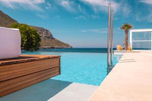 a swimming pool with a view of the ocean at Kantouni Beach Boutique Hotel in Panormos Kalymnos