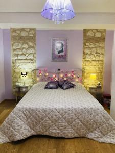 a bedroom with a large bed with a purple lamp at Stephanie's Home in Pettorano sul Gizio