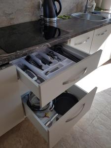 a kitchen with an open drawer with utensils at Kambarių nuoma Naujojoje Akmenėje in Naujoji Akmenė