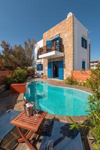 a villa with a swimming pool in front of a house at Blue Sea Villa in Gennadi