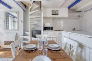 サナリー・シュル・メールにあるBleu Azur - avec vue sur le portのテーブルと椅子のあるキッチンとダイニングルーム