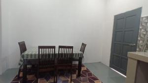 a dining room with a table and two chairs and a door at Family PCB Homestay in Kota Bharu